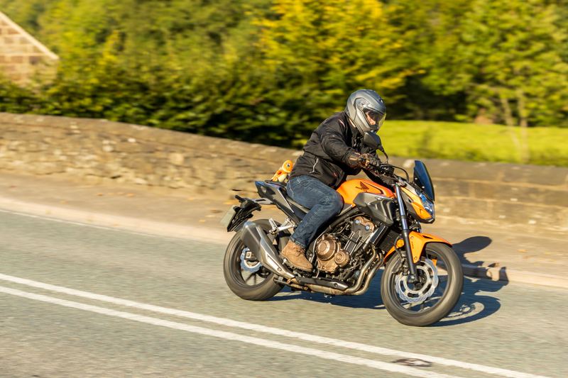Peter riding his orange Honda CB500F on a country road